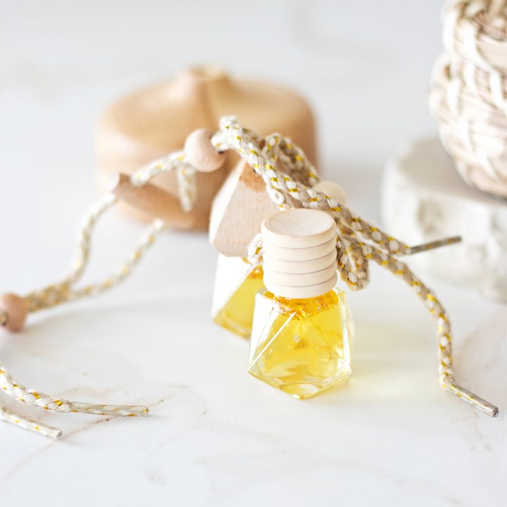Glass essential oil car diffuser with a wood top.